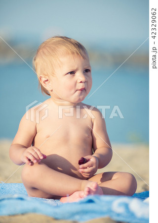 Cute baby playing with toys on sandy beach near the sea. Cute baby playing with toys on sandy beach near the sea. 42329062