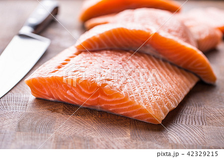Close-up raw salmon fillets on wooden table 42329215