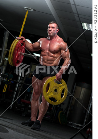 Strong mature man with relief body posing in gym 42331291