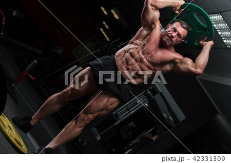 Strong mature man with relief body posing in gym 42331309