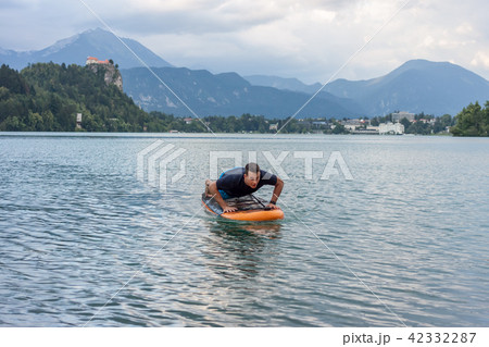young man exercising on paddle board at the lake young man exercising on paddle board at the lake 42332287
