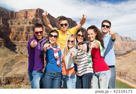 happy friends pointing at you over grand canyon 42339175