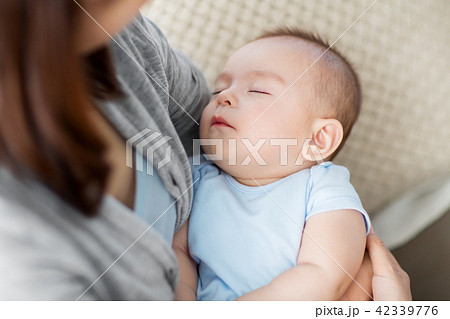 close up of mother holding sleeping asian baby boy 42339776