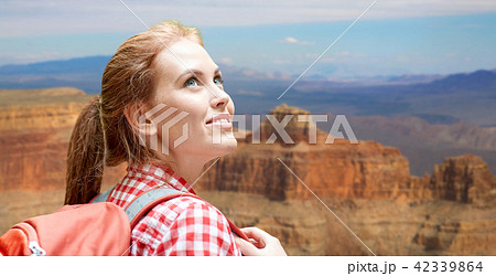 smiling woman with backpack over grand canyon smiling woman with backpack over grand canyon 42339864
