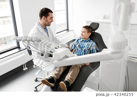 dentist talking to kid patient at dental clinic dentist talking to kid patient at dental clinic 42340255