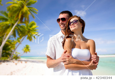 happy couple in sunglasses over tropical beach happy couple in sunglasses over tropical beach 42340344