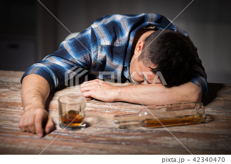 drunk man with glass of alcohol on table at night drunk man with glass of alcohol on table at night 42340470