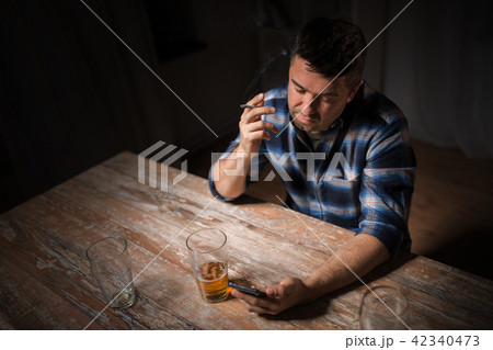 man with cellphone drinking alcohol and smoking 42340473