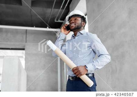 architect with blueprint calling on smartphone architect with blueprint calling on smartphone 42340507