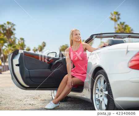 woman posing in convertible car over venice beach 42340606