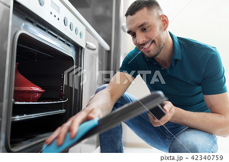 man with rag cleaning oven door at home kitchen man with rag cleaning oven door at home kitchen 42340759