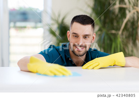 smiling man cleaning table with cloth at home smiling man cleaning table with cloth at home 42340805