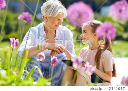 grandmother and girl with tablet pc at garden grandmother and girl with tablet pc at garden 42341037