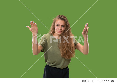 Beautiful female half-length portrait isolated on green studio backgroud. The young emotional 42345430