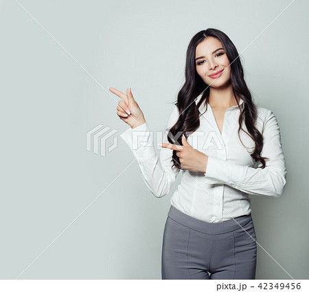 Smiling businesswoman pointing her finger to empty 42349456