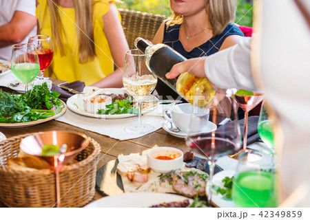 Professional waiter in uniform serving wine to guests of event. Catering or celebration concept 42349859