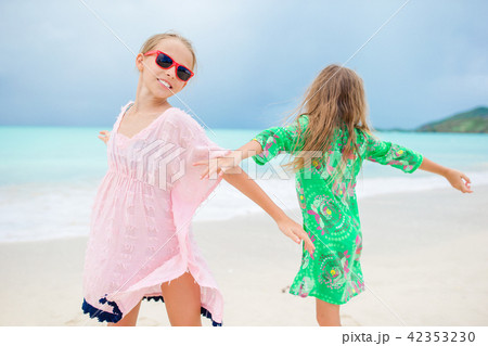 Happy girls having fun and enjoying vacation on tropical beach with white sand and turquoise ocean Happy girls having fun and enjoying vacation on tropical beach with white sand and turquoise ocean 42353230
