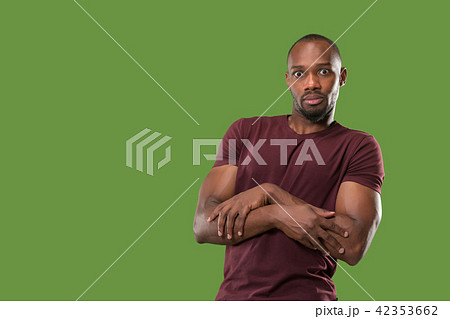 The young attractive man looking suprised isolated on green The young attractive man looking suprised isolated on green 42353662