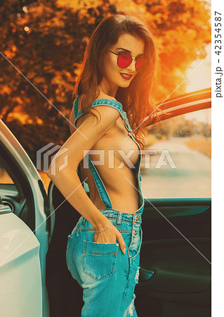 sexy brunette in denim overalls and sunglasses  42354587