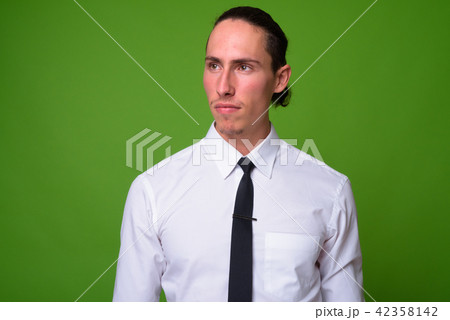 Young handsome businessman against green background 42358142