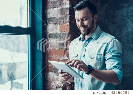 Bearded Man Call Using Tablet PC near Window. Bearded Man Call Using Tablet PC near Window. 42360595