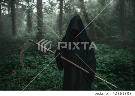 Death in a black hoodie with a scythe in forest 42361308