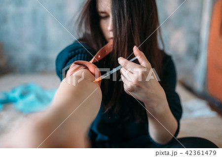 Female junkie with syringe doing an injection dose Female junkie with syringe doing an injection dose 42361479