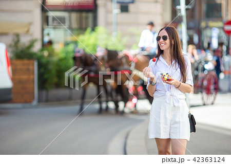 Tourist girl enjoying a stroll through Vienna and looking at the beautiful horses in the carriage Tourist girl enjoying a stroll through Vienna and looking at the beautiful horses in the carriage 42363124