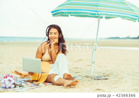 Plus size young woman sitting on the beach. 42366366
