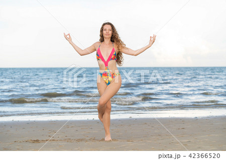 Young Woman Practicing Yoga Pose On The Beach In Summer. Healthy