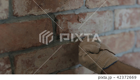 closeup of worker forming seam between bricks closeup of worker forming seam between bricks 42372669