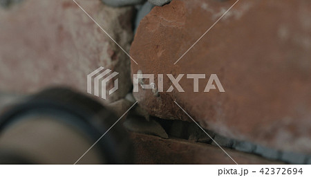 closeup of worker filling seam between bricks with mortar from sealant gun 42372694