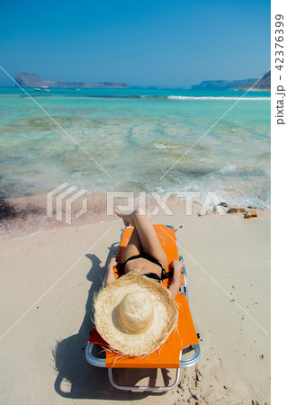 girl lying down on lounger on Balos beach girl lying down on lounger on Balos beach 42376399