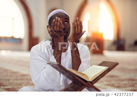 African Muslim Man Making Traditional Prayer To God While Wearing Dishdasha African Muslim Man Making Traditional Prayer To God While Wearing Dishdasha 42377237