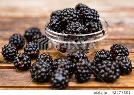 Fresh ripe blackberries in bowl on wooden table 42377801