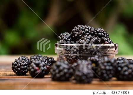 Fresh ripe blackberries in bowl on wooden table 42377803