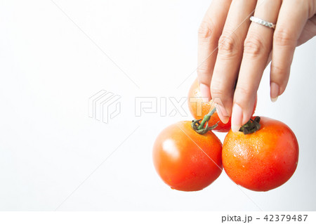 Beautiful woman hand with tomatoes on white Beautiful woman hand with tomatoes on white 42379487