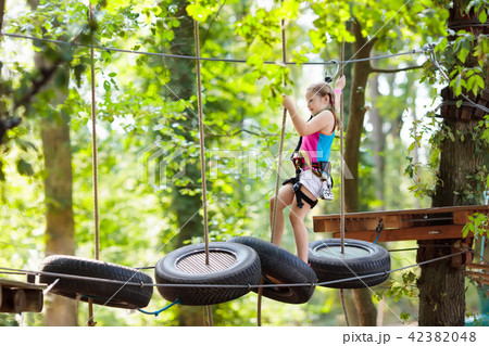 Child in adventure park. Kids climbing rope trail. 42382048