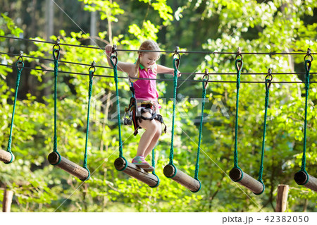 Child in adventure park. Kids climbing rope trail. 42382050