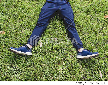 Man laying down on grass relaxing taking it easy Man laying down on grass relaxing taking it easy 42387324