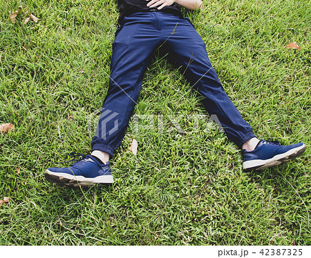 Man laying down on grass relaxing taking it easy Man laying down on grass relaxing taking it easy 42387325