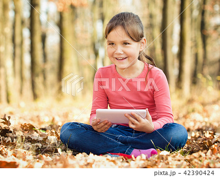 Little girl is reading from tablet 42390424