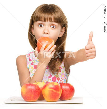 Little girl with apples is showing thumb up sign 42390779