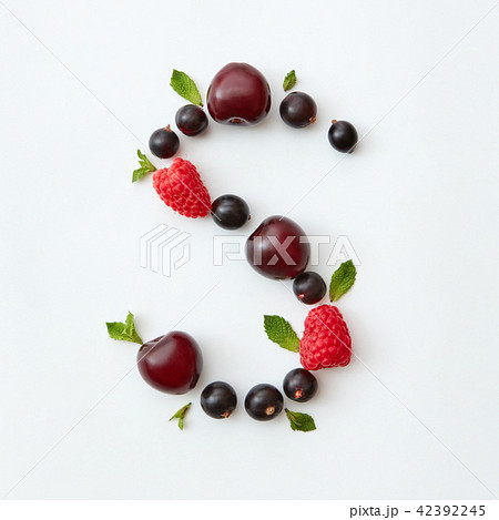 Flat lay pattern of letter S english alphabet from natural ripe berries - black currant, cherries 42392245