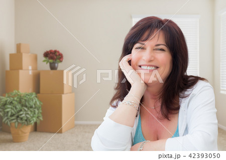 Middle Aged Woman Relaxing Inside Empty Room With Moving Boxes 42393050