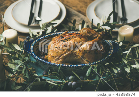 Whole roasted chicken decorated with olive tree branch, selective focus Whole roasted chicken decorated with olive tree branch, selective focus 42393874