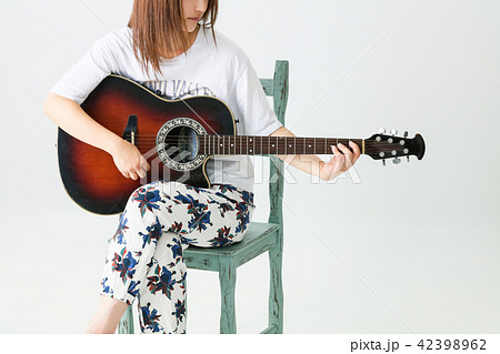 椅子に座ってギターを弾く女の子の写真素材 42398962 Pixta