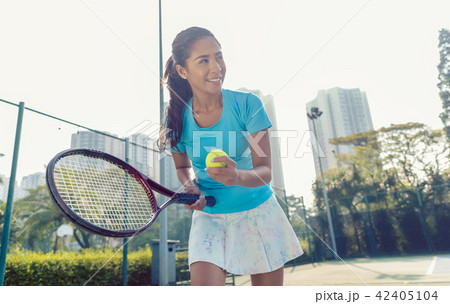 Professional female player smiling while serving during tennis match 42405104