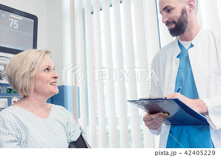 Doctor talking to patient in recovery room of hospital Doctor talking to patient in recovery room of hospital 42405229