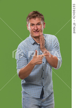 The young man whispering a secret behind her hand over green background 42406193